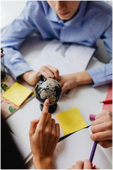 Children studying geography using a globe in a cla
