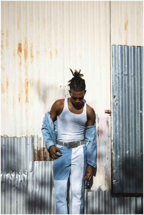 Stylish young man in trendy denim attire against a