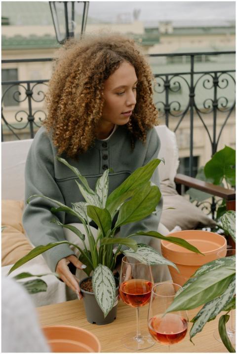 Woman with curly hair gardening on a rooftop terra