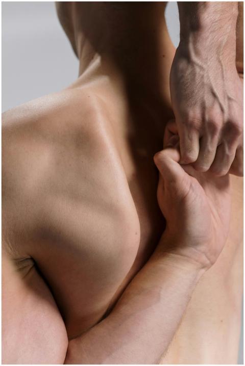 Close-up of a man's muscular back and arms in a yo