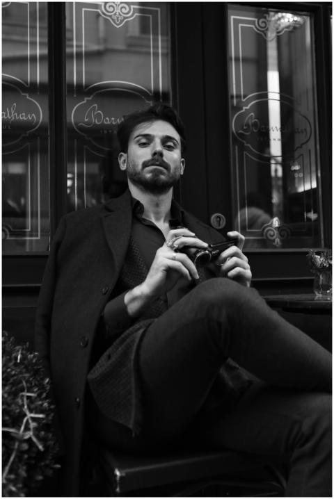 A well-dressed man with a beard and mustache sitti