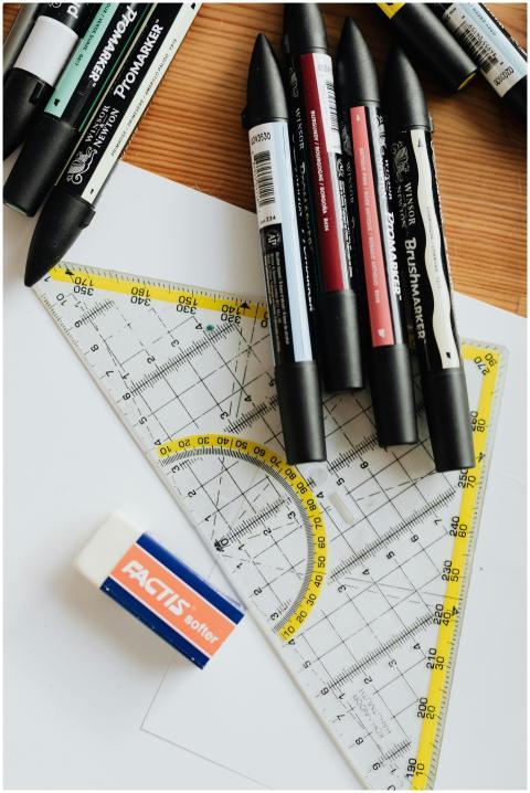 Top view of various markers and plastic drawing tr