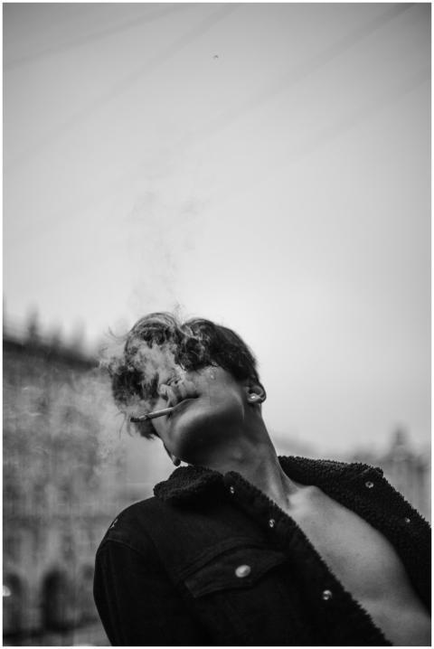 Dramatic monochrome portrait of a man smoking outd