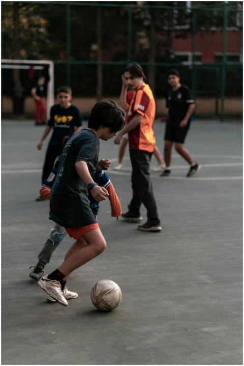 Boys energetically playing soccer on an outdoor co