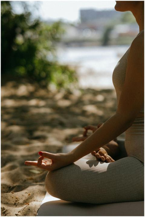 A woman practices yoga and meditation on a sandy b