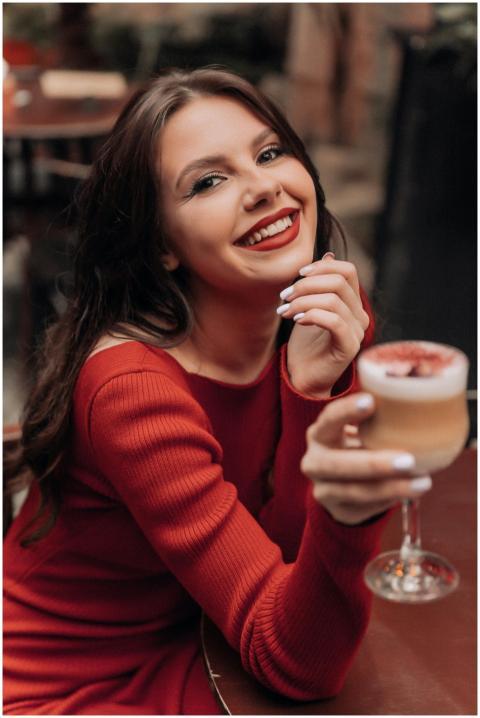An elegant woman in a red dress smiling while hold
