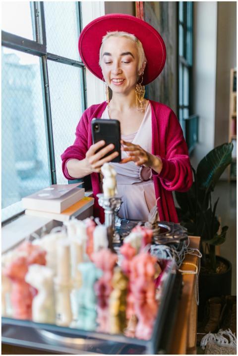 Woman photographing unique candles for her small b