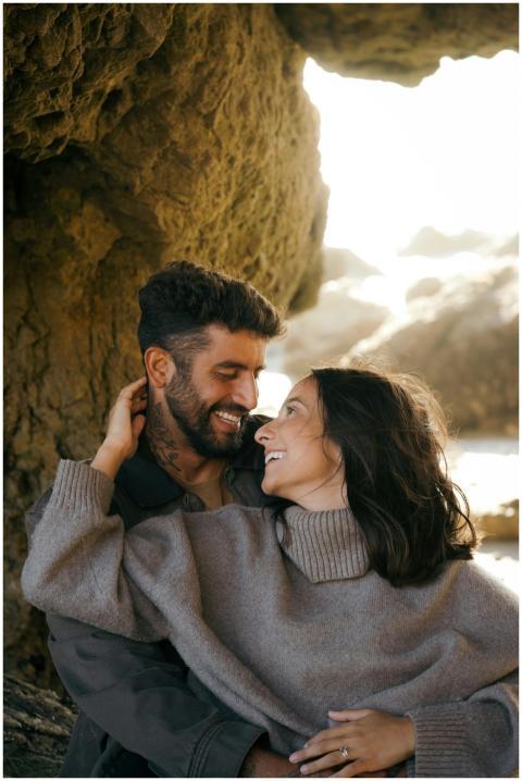 A loving couple embraces near rocky formations on