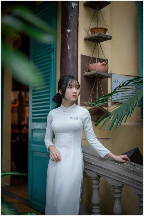 Young woman in traditional white dress standing by