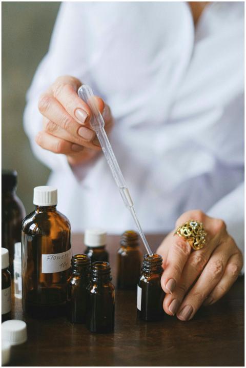 Close-up of a person using a dropper with essentia