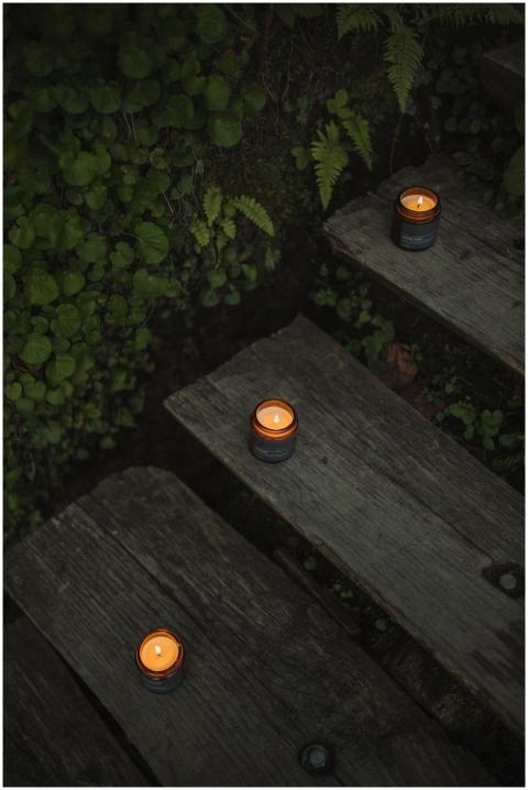 Warm lit candles arranged on wooden steps surround
