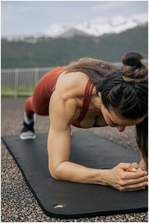 Focused woman doing a plank exercise on a yoga mat