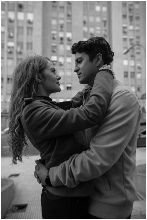 A couple embraces in a city setting, captured in a