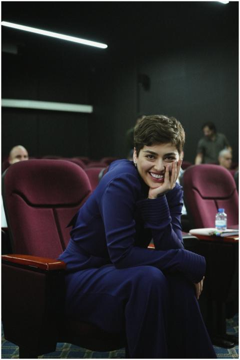 Confident woman smiling in theater seating during