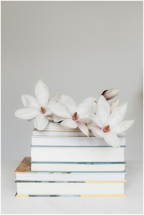 Elegant stack of books adorned with white magnolia