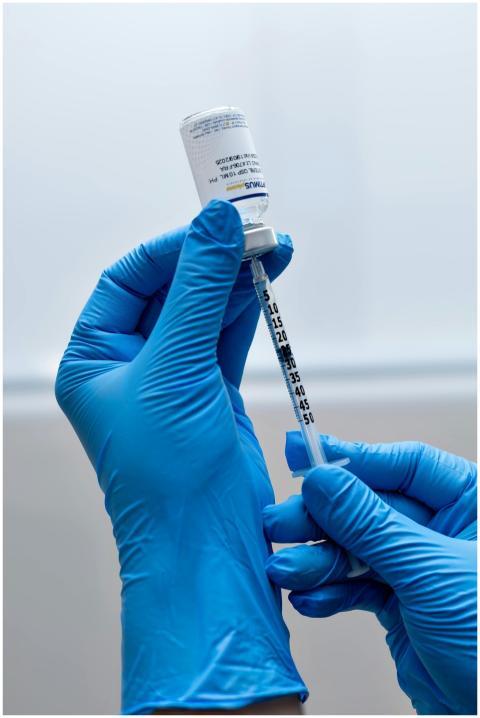 Healthcare worker prepares syringe with vaccine fo