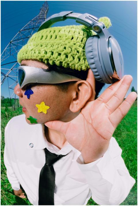 A man outdoors wearing headphones and fun accessor