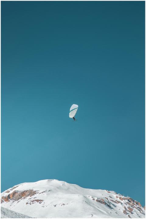 Thrilling paragliding adventure above snow-covered