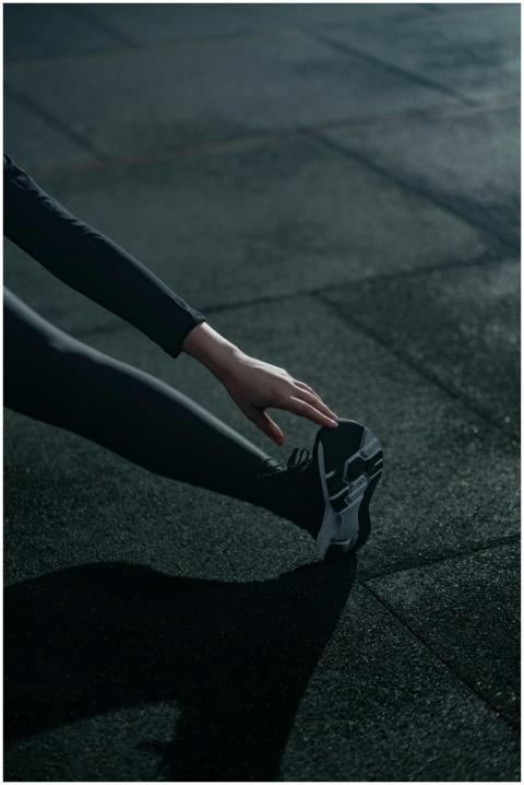 A person in activewear performing a stretching exe