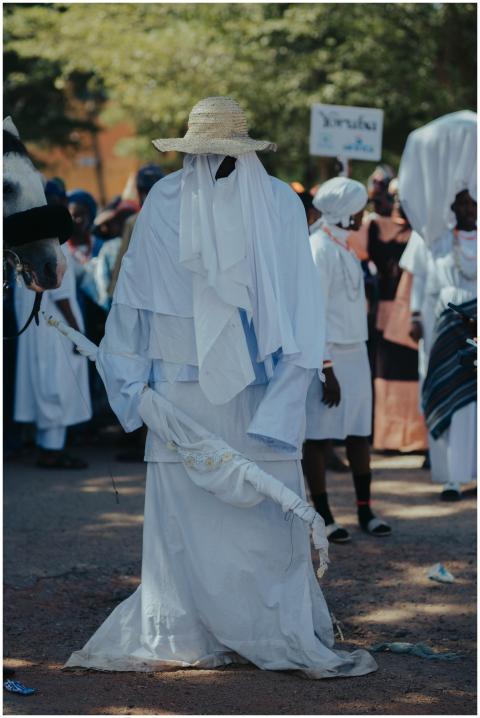 Masked figure in traditional attire during a livel