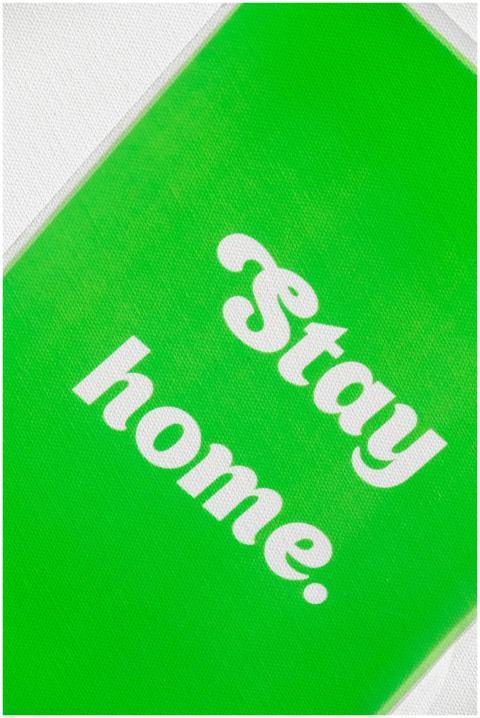 Bright green sign with 'Stay Home' text promoting