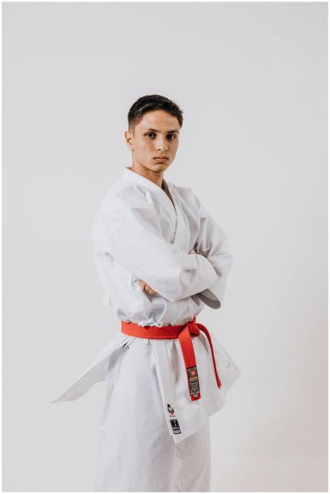 Teen karate practitioner poses confidently in a wh