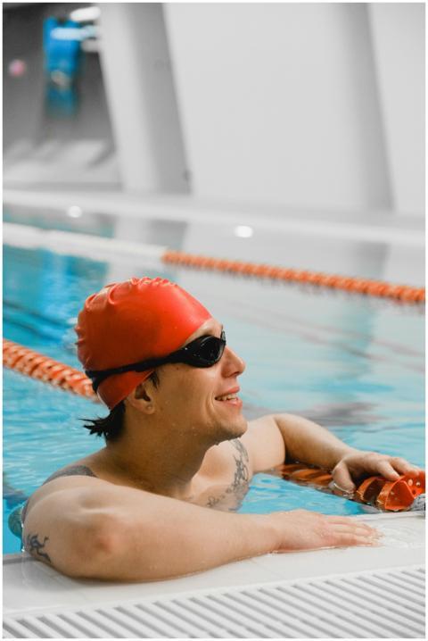 Athletic man relaxing in an indoor pool with a red