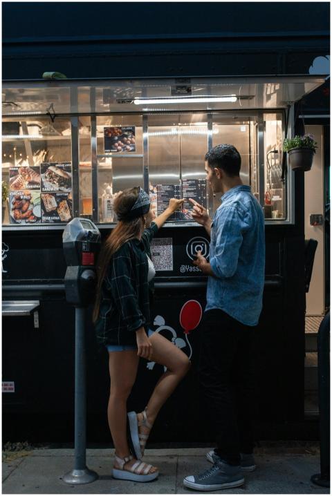 A couple orders food at a vibrant street food truc