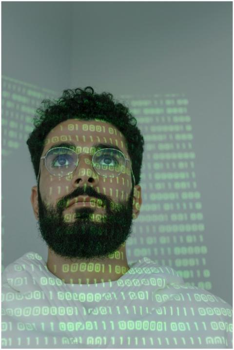 A bearded man with eyeglasses analyzing data in a