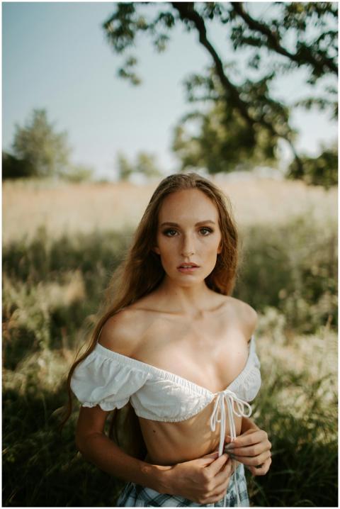A serene portrait of a woman in a white top in a s