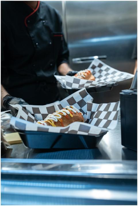 Close-up of gourmet hot dogs with condiments serve