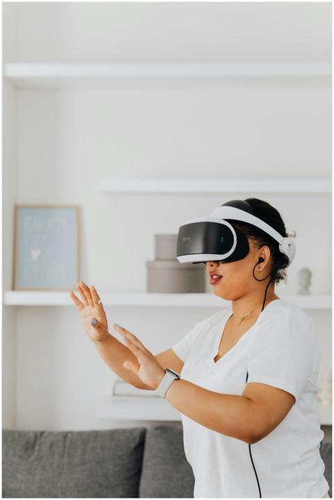 Black woman using VR headset at home, immersed in