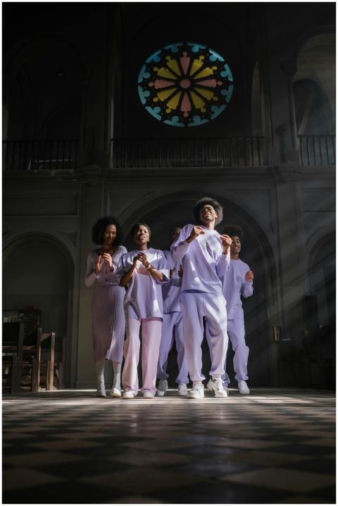 Diverse group of people singing in a sunlit church