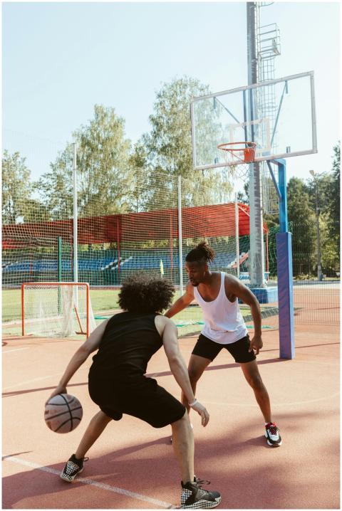 Two men engaged in a basketball game on an outdoor