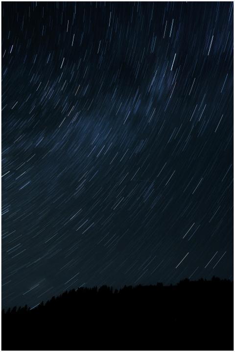 Long exposure captures star trails over mountains