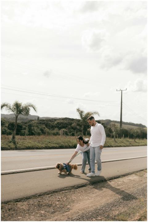 Young couple strolling with their dog on a sunny r