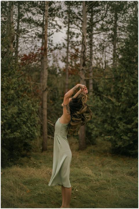 A woman with tattoos tosses her hair back, enjoyin