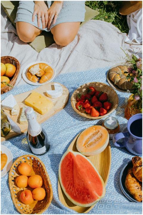 A cozy summer picnic featuring fresh fruits, chees