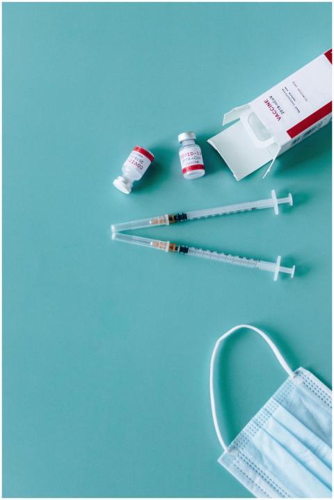 Syringes, vaccine vials, and face mask ready for C