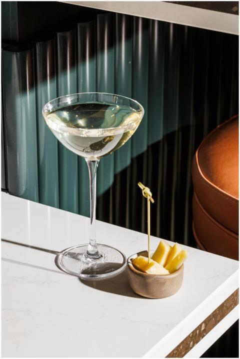 A close-up of a cocktail and cheese pairing on a s