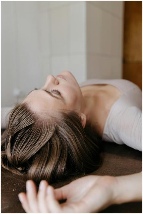 Woman in long sleeves lying on a wooden surface, e