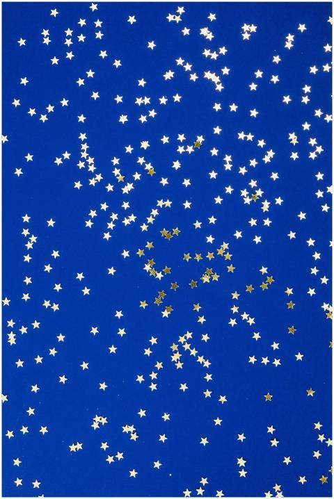 Golden star confetti scattered on a deep blue surf