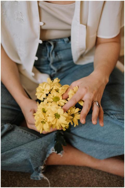 Close-up of a woman holding yellow flowers while s