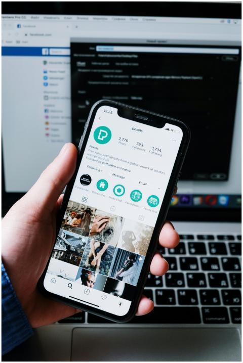 Hand holding smartphone displaying social media ap