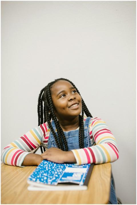 A cheerful young black girl smiling while sitting