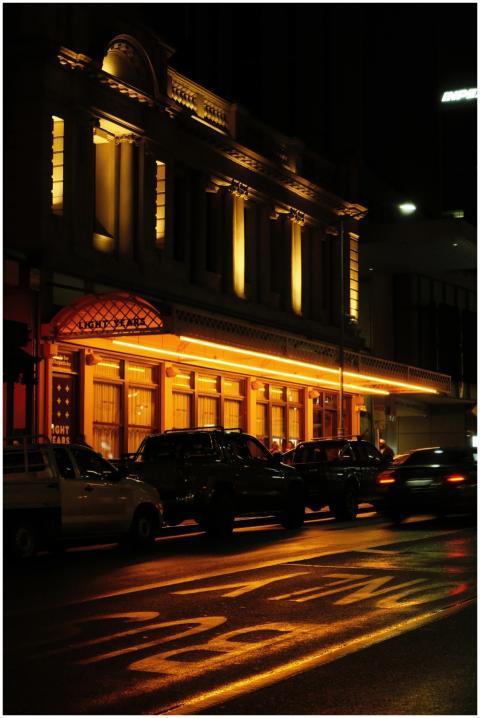 A beautifully lit historic building with parked ca