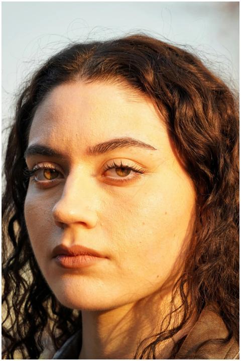 Close-up portrait of a young woman with curly hair