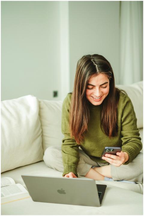 Young woman in cozy setting, engaging with smartph
