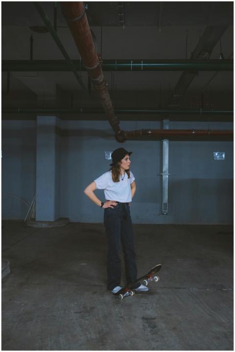 Woman skateboarder standing in an industrial indoo