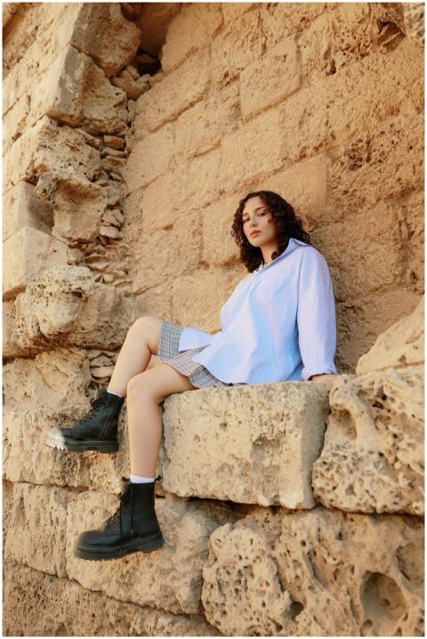 Woman sitting on ancient stone ruins in Cyprus, we